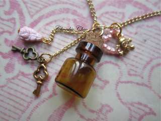 Brown glass bottle with keys and a pink rose on two dangle chains, a 