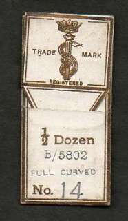 This is an antique paper package with four curved surgical needles.